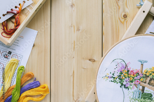 Fotografija Cross-stitch set : hoop with embroidered flowers pattern, canvas, colorful threads, color palette