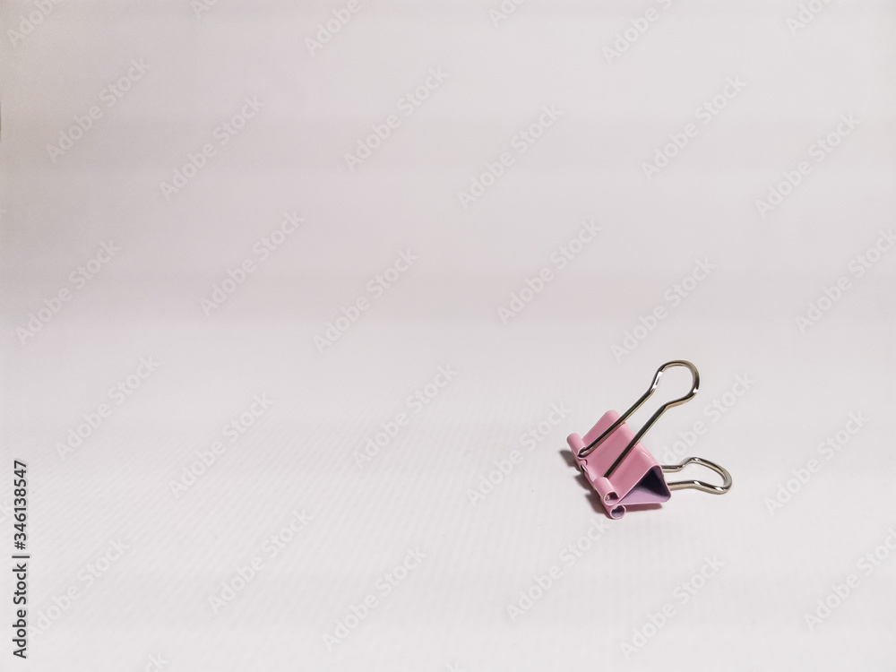 Fototapeta premium Pink paper clip on a white background. Office stationery. Space for your text.
