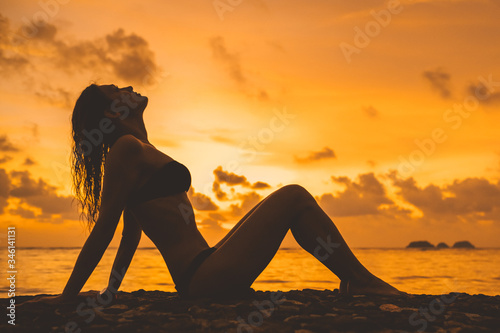 Woman silhouette against sunset on the beach