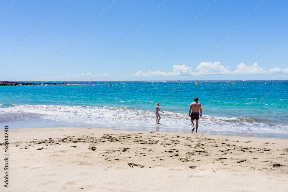 Girl and her father  having fun at the empty beach. Crisis in turism. Family vacation.