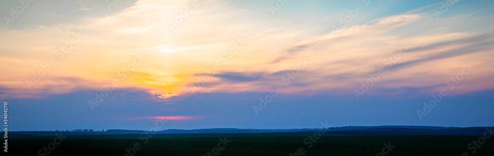 Wonderful panorama with picturesque clouds over the field during sunset or sunrise - obrazy, fototapety, plakaty 