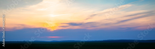 Wonderful panorama with picturesque clouds over the field during sunset or sunrise