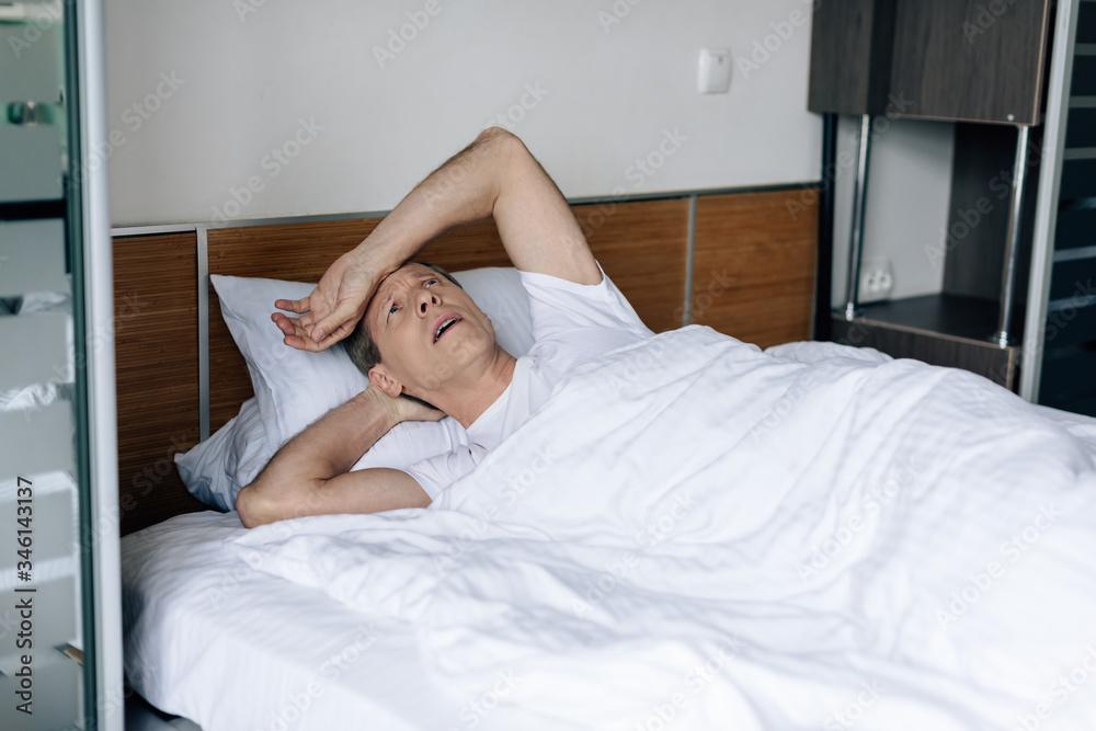 sick man lying on bed and feeling unwell sick man lying on bed and feeling unwell