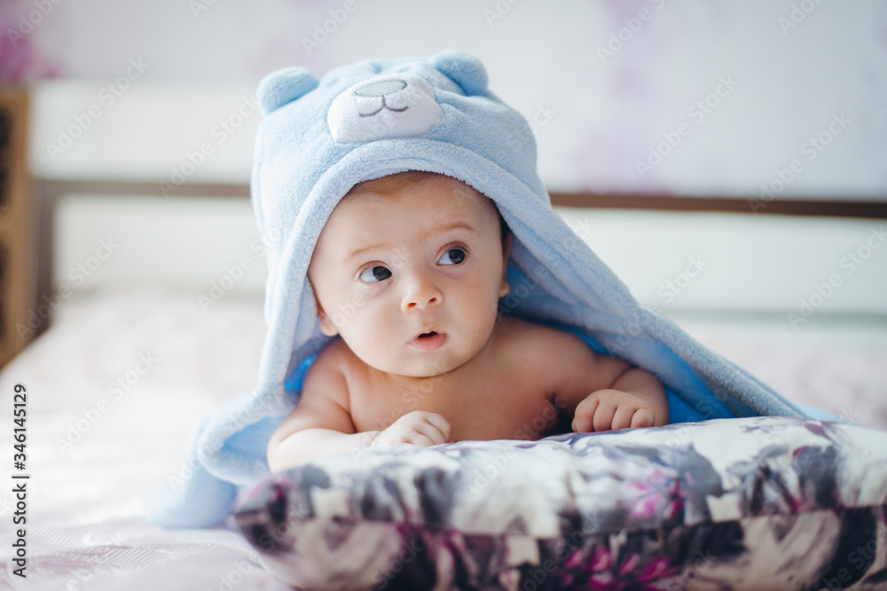 3 months baby boy weared in funny hat lying down on a blanket. A portrait of a cute blond baby 3 months baby boy weared in funny hat lying down on a blanket. A portrait of a cute blond baby