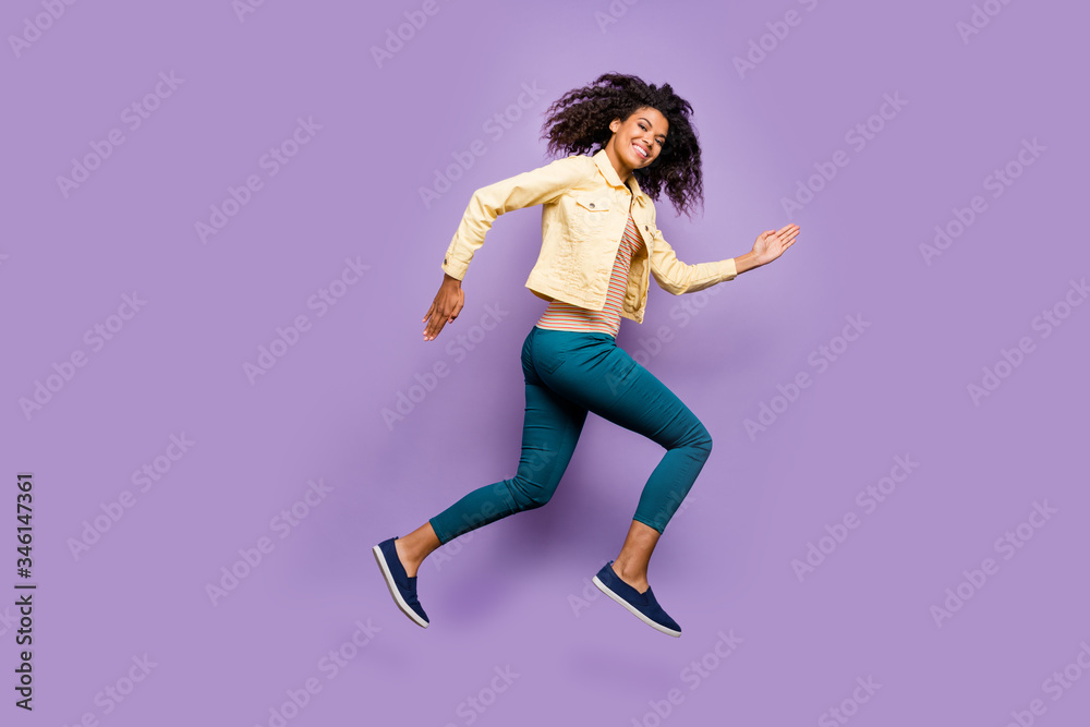 Full length body size photo of cheerful positive cute nice girl in pants trousers shirt yellow running jumping isolated pastel violet color background