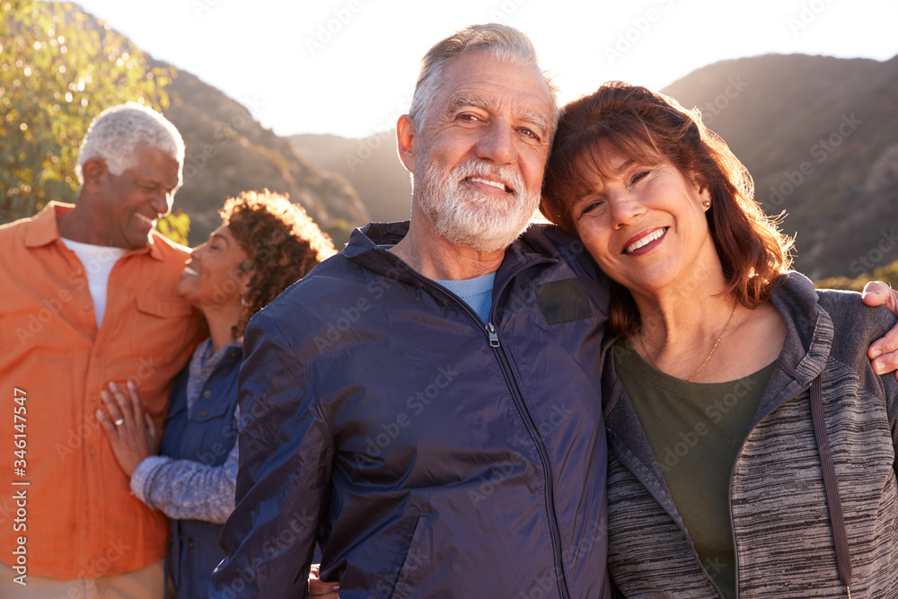 Portrait Of Smiling Senior Friends Walking In Countryside Together