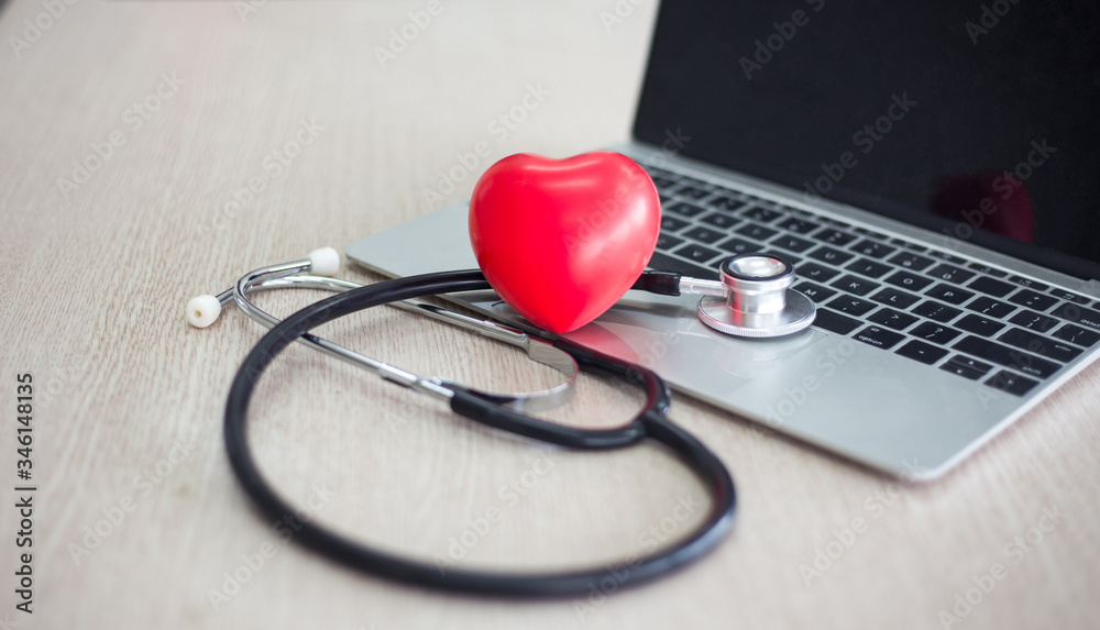 Stethoscope, mini hearth and laptop or computer on doctor desk prepare in hospital and clinic for diagnosis patient health for therapy and treatment with medicine Stethoscope, mini hearth and laptop or computer on doctor desk prepare in hospital and clinic for diagnosis patient health for therapy and treatment with medicine