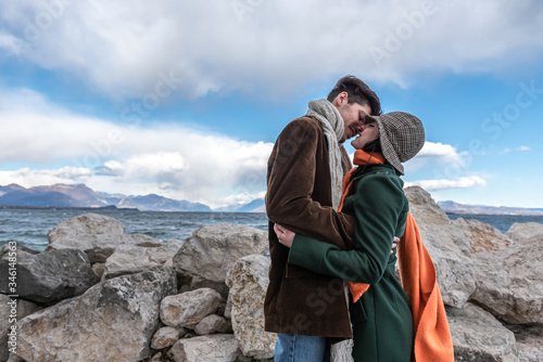 Young Couple. Romantic couple on the beach. Happy couple running on the beach on the background of the lake and mountains.