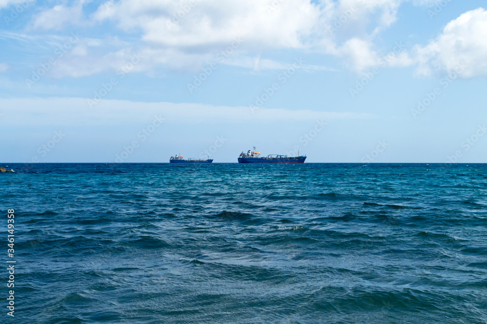 Blue sea, sky and ships on the horizon
