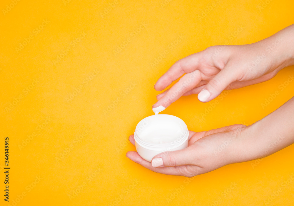 Women's hands use cream from a jar. Care cosmetics, skin care.