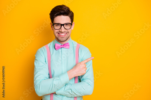 Portrait of positive cheerful man point index finger direct way ads promotion suggest select wear good look outfit isolated over shine color background