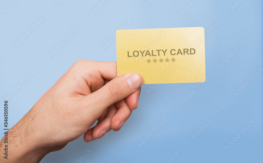 Marketing and client relations. Young guy showing loyalty card on blue background, close up of hand. Collage