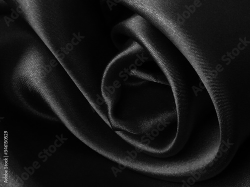 Shiny black crumpled fabric background.. Liquid wavy shape. photo