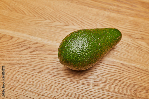green avocado on a wooden table