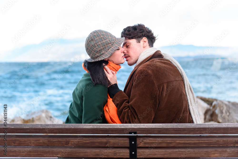 The attractive girl and man young. Young couple kissing outdoors.  Romantic mood. Couple in love. Street shot. Lake and mountains background