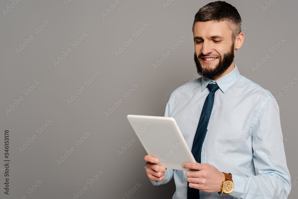 smiling handsome bearded businessman with digital tablet on grey background smiling handsome bearded businessman with digital tablet on grey background
