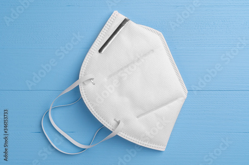 White respiratory mask n95 on a light blue wooden background close-up. Coronavirus Medical Protection Concept