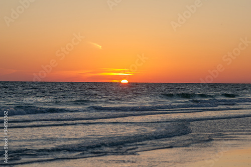 Stunningly beautiful orange sunset over ocean and beach in Florida