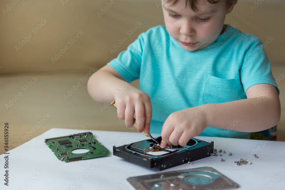 An inquisitive child is experimenting with a broken hard drive An inquisitive child is experimenting with a broken hard drive