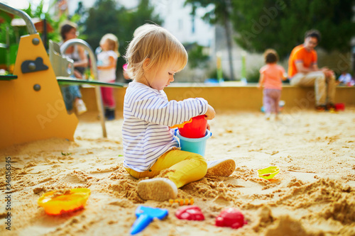 Fotografie, Obraz Adorable little girl on playground in sandpit