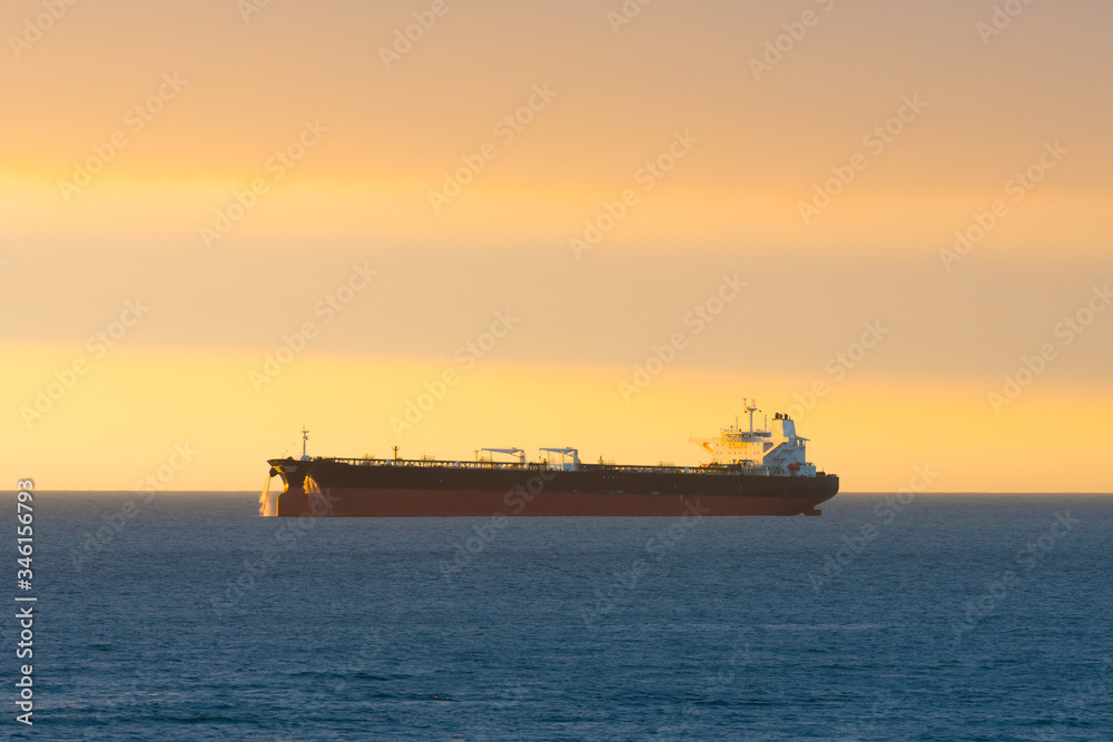 Cargo ship at sunset in the coasts of Chile outside the port of Valparaiso.
