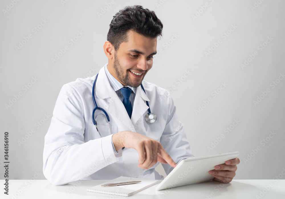 Young smiling internist using tablet computer Young smiling internist using tablet computer