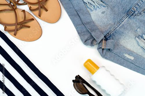 Flat lay summer traveler beach accessories. travel or vacation concept. Copy space layout. Jean, sandals and sun glasses