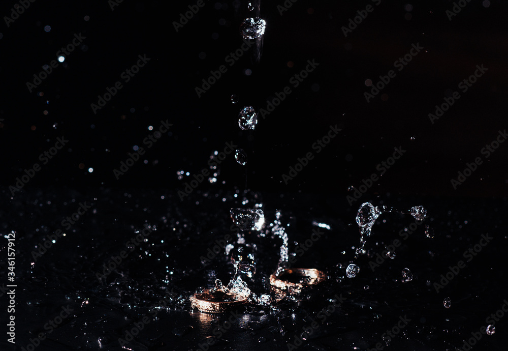 wedding rings with the water splash on black background wedding rings with the water splash on black background