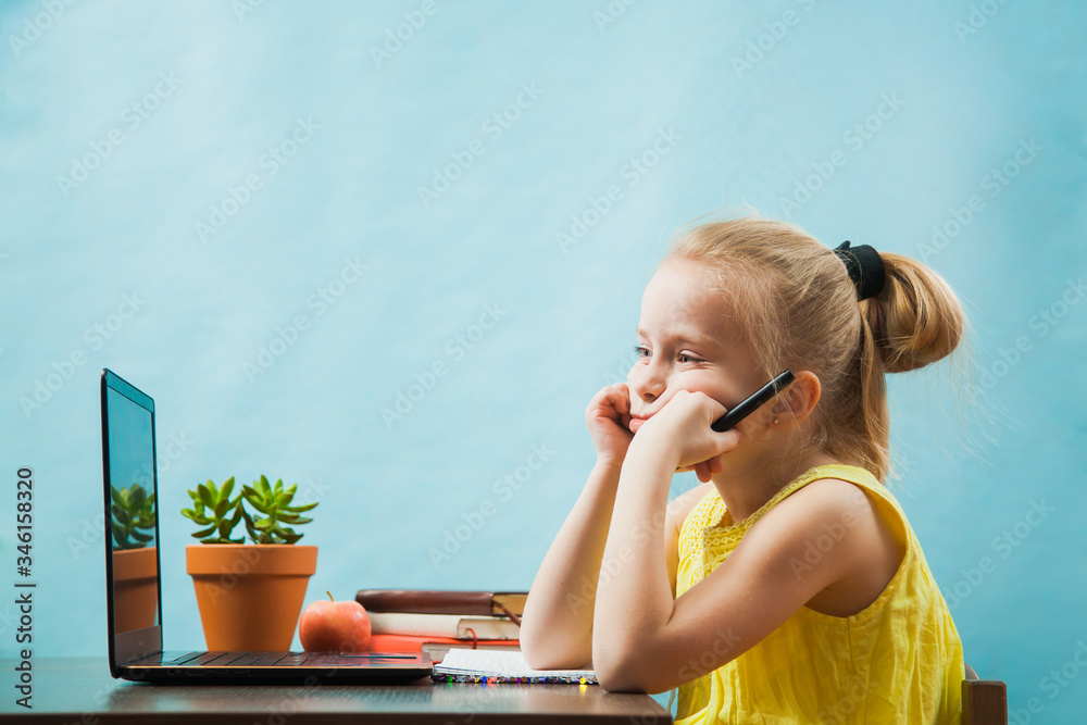 Fototapeta premium Sad elementary student girl homeschooling on laptop online by internet.