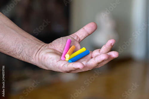 male painter artist hand holding different color pastel crayons