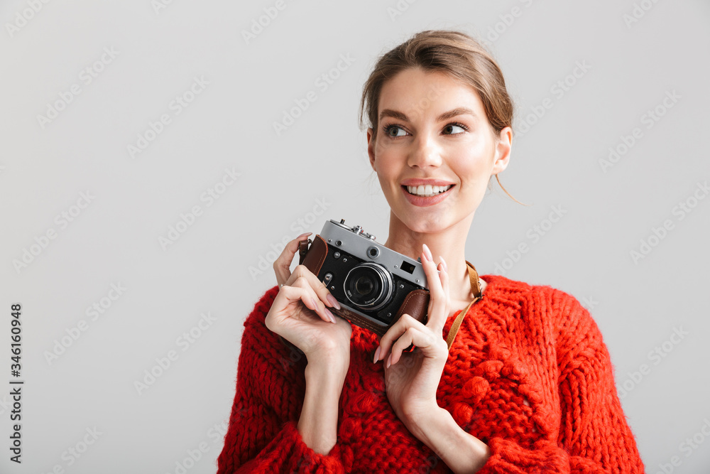 Image of young cheerful woman smiling and using retro camera Image of young cheerful woman smiling and using retro camera