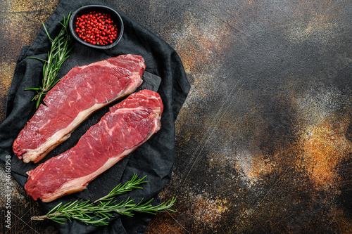 Fresh meat, marbled beef, raw New York strip steak. Dark background. Space for text. Flat lay.