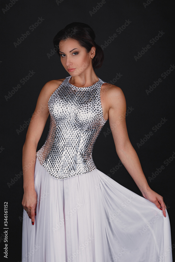 Pretty girl posing in a fashion dress over black background Pretty girl posing in a fashion dress over black background