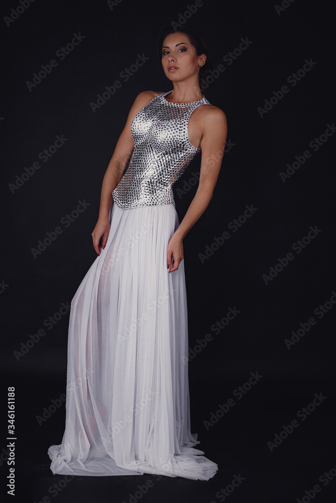 Pretty girl posing in a fashion dress over black background Pretty girl posing in a fashion dress over black background
