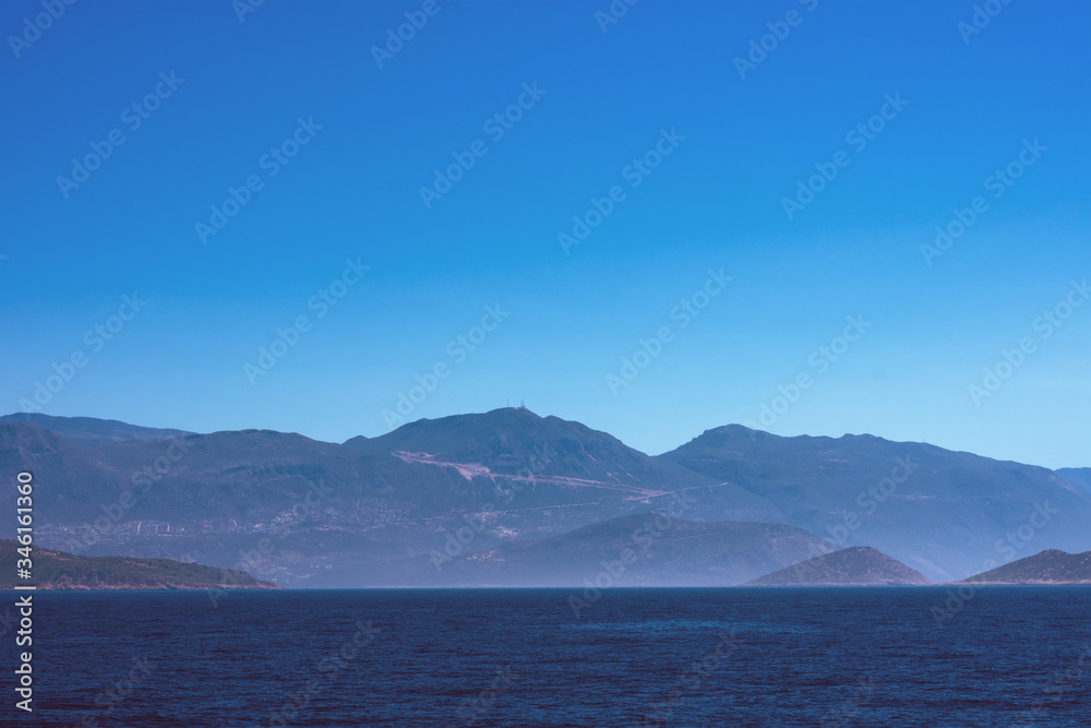 Toned background with copy space made of seascape with mountains in fog
