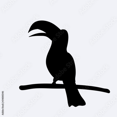 Black silhouette of a cute toucan sitting on branch. Vector
