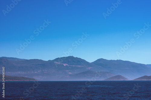 Toned background with copy space made of seascape with mountains in fog