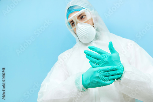 close-up portrait of tired doctor after shift in the hospital. The doctor in protective clothing - glasses, mask, gloves on white background. The doctor treating patients with coronavirus. Covid-2019