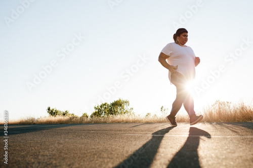 Fotografija Overweight woman jogging on the highway