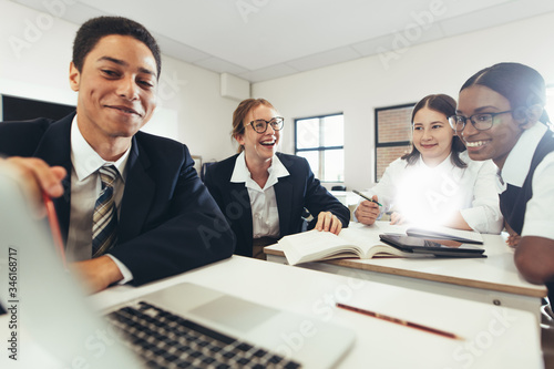 Φωτογραφία Group of student studying together on a laptop in classroom