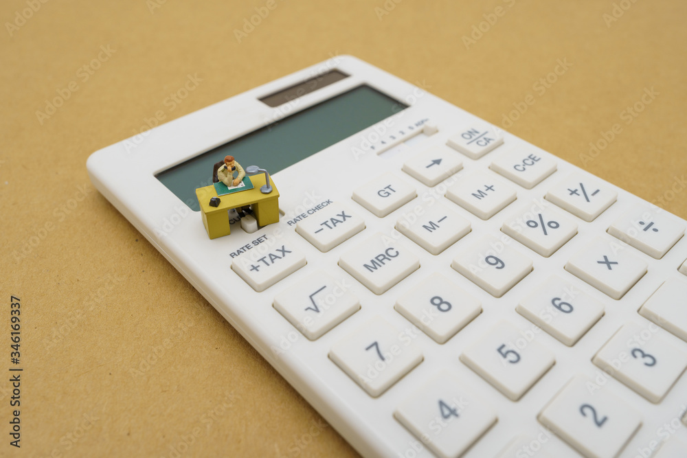 Miniature people Pay queue Annual income (TAX) for the year on calculator. using as background business concept and finance concept with copy space for your text or design. Miniature people Pay queue Annual income (TAX) for the year on calculator. using as background business concept and finance concept with copy space for your text or design.