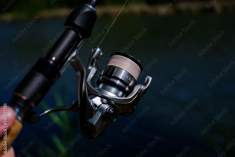 .Spinning the rod against the background of the pond professional tool for fishing a predatory fish on the line .Spinning the rod against the background of the pond professional tool for fishing a predatory fish on the line