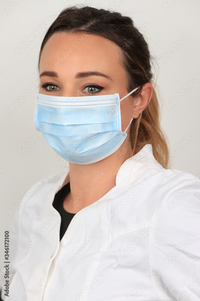 Jeune femme portant un masque chirurgical pour se proteger des virus sur fond blanc Jeune femme portant un masque chirurgical pour se proteger des virus sur fond blanc