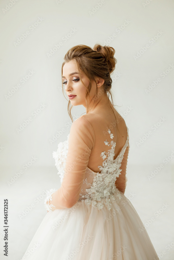 bride in white wedding dress. happy beautiful young woman in white traditional wedding dress on white background. big windows and white walls. bride in white wedding dress. happy beautiful young woman in white traditional wedding dress on white background. big windows and white walls.
