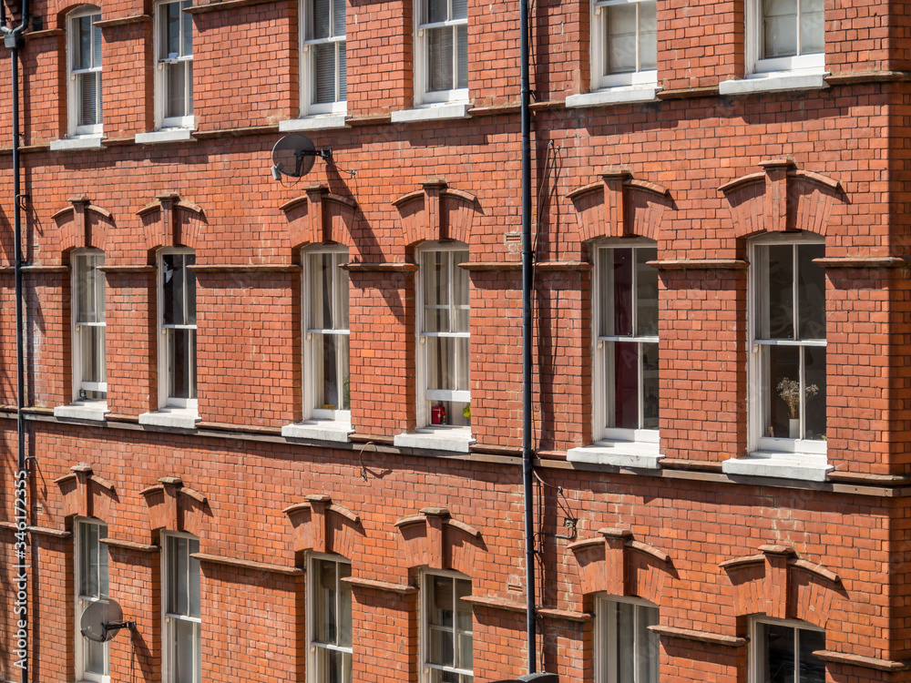 Obraz premium East London, England UK. Traditional red brick housing and flats. Sash windows. Concept, buying, renting, estate agent, urban housing and living in the city, London lockdown, copy space