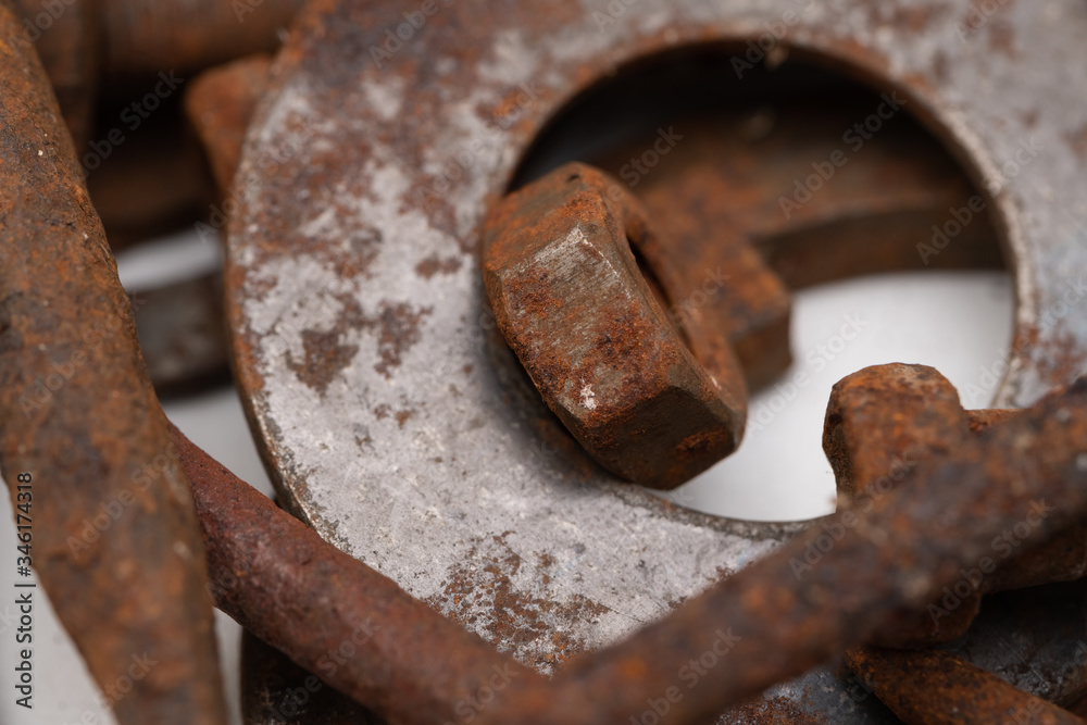 a mountain of various rusty metal construction parts on a white background. Selective focus a mountain of various rusty metal construction parts on a white background. Selective focus
