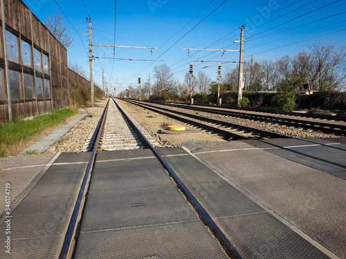 Under clear skies, the railway line can be seen. The multiple railway tracks are viewed from the middle and continue into the distance.