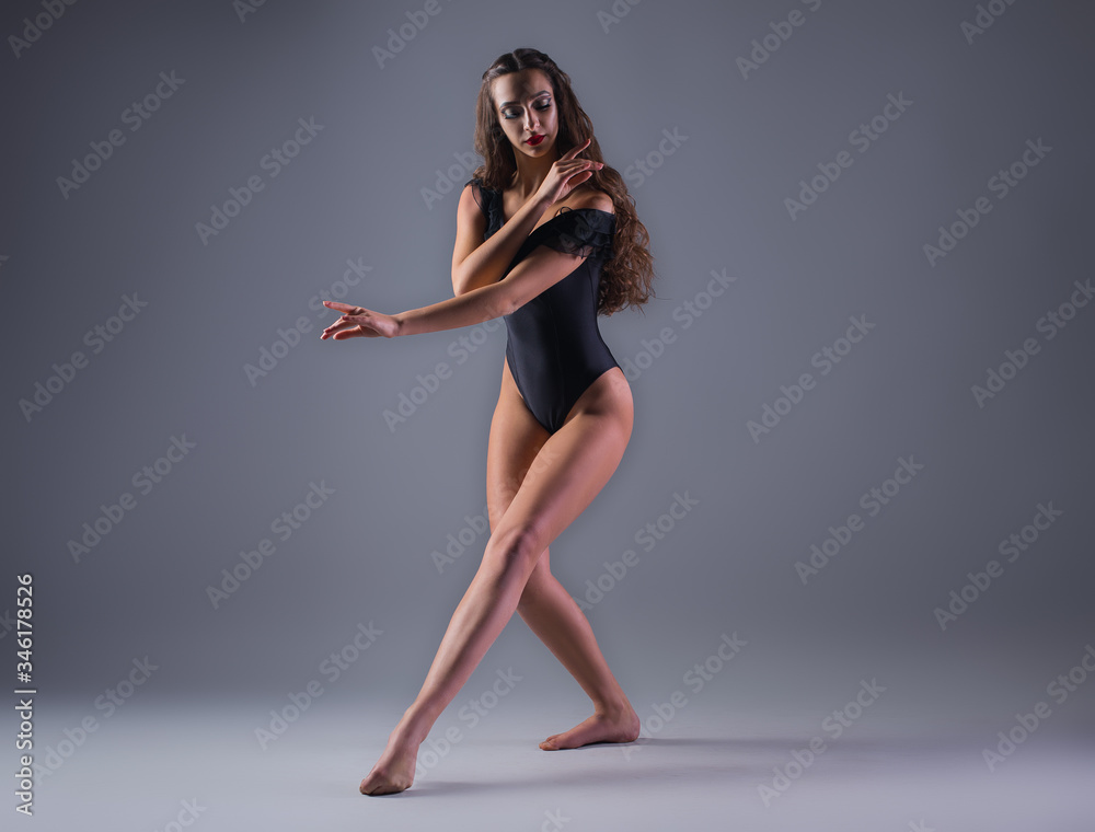Young girl dancer in black outfit on gray background