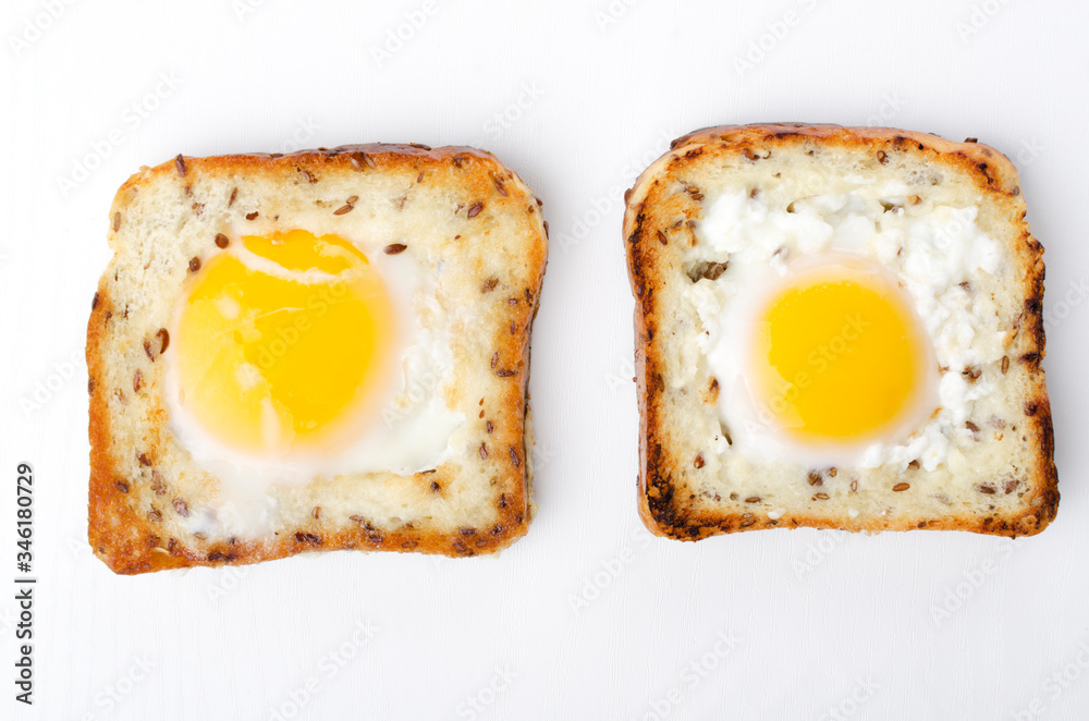 Top view of two slice of bread and fried eggs in it.Tasty eggs in the hole on the white background
Top view of two slice of bread and fried eggs in it.Tasty eggs in the hole on the white background