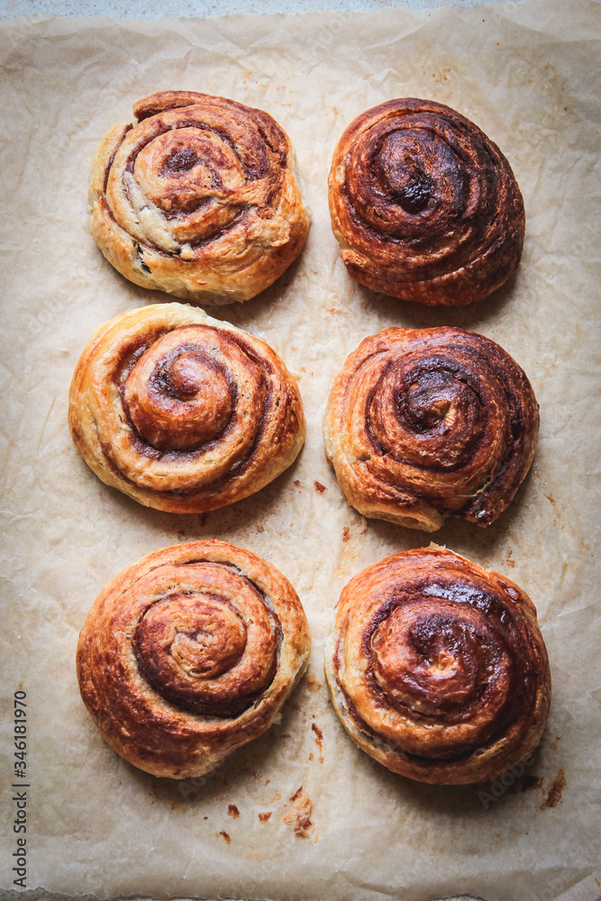 Cinnamon rolls on a baking paper shot from above. Minimal styling. Food pattern Cinnamon rolls on a baking paper shot from above. Minimal styling. Food pattern